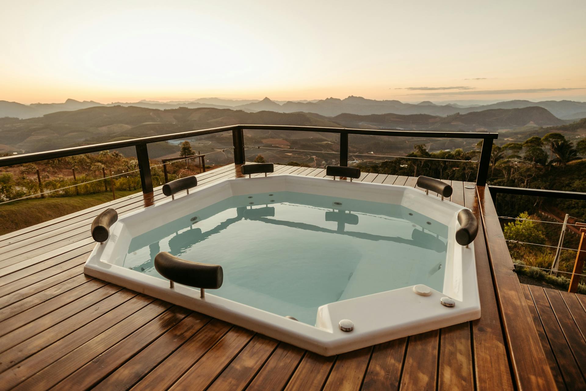 Hot tub on a deck overlooking mountains at sunset